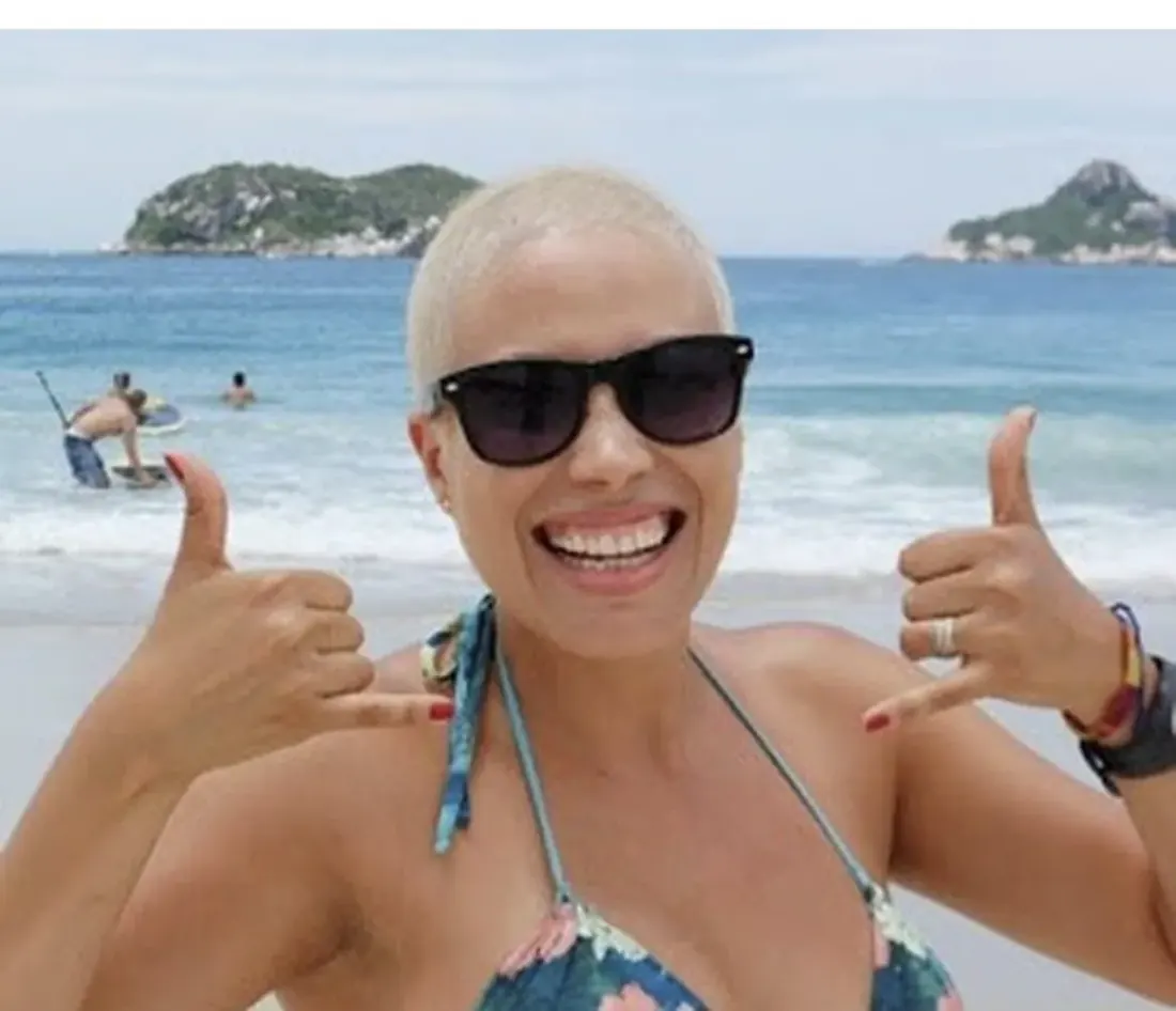 Patrícia na praia depois do tratamento, sorrindo